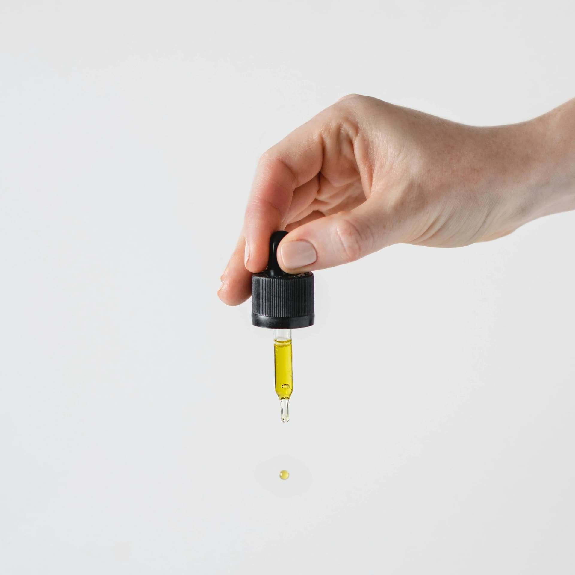 Hand using CBD oil dropper demonstrating proper usage